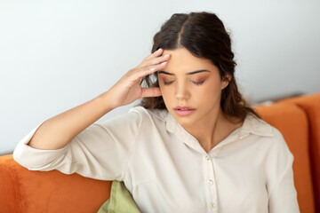 Headache Concept. Stressed young lady suffering from migraine at home