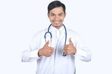 Fototapeta premium Portrait of doctor with stethoscope and showing thumbs up on white background.