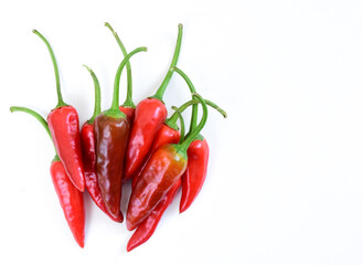 Pile of hot peppers with space for text. Different red hot chili peppers isolated on white background