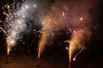Three home fireworks sending sparks upwards