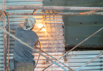 Fototapeta premium Worker cutting metal wall with metal cutting torch.