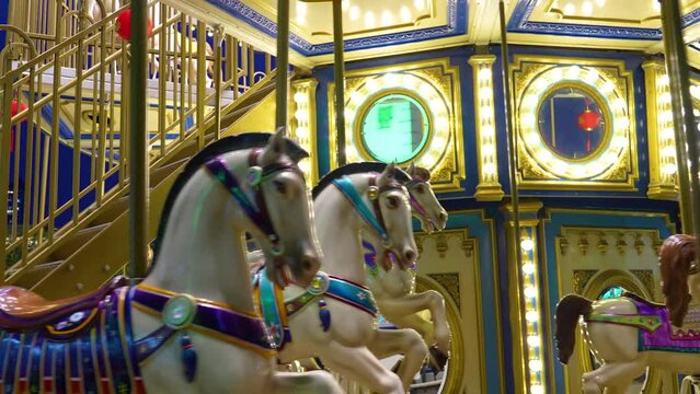 Old French carousel spins in a holiday park. Elephant horses on a traditional vintage fairground carousel. Carousel with horses in the evening at night with bright lights and flashes