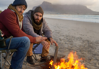 Campfire, friends and portrait with men by the beach at sunset with vacation and camping. Ocean,...