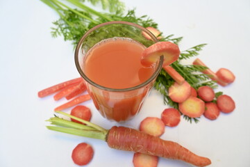 Carrot juice on white background. Healthy carrot juice in a glass and fresh carrots on a table. Healthy dieting drinks. Fresh carrot juice of organic vegetable in domestic.