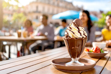 Eisbecher mit Schokolade im Hintergrund ein Cafe 