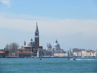 San Giorgio Maggiore island, bell tower, church and boats in Venice on a sunny spring day
