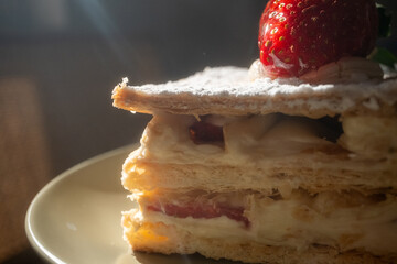 Mille-feuille in restaurant on khaki green plate in close-up
