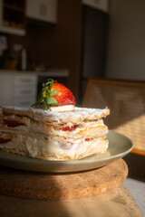 Mille-feuille in restaurant on khaki green plate in close-up

