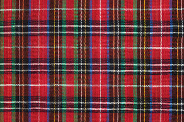 Close-up of Scottish tartan fabric in red, green, yellow and blue colors. Traditional Scottish clothing. Background for your design