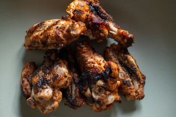 High-fire fried chicken wings served on a large deep khaki green plate on the restaurant table	