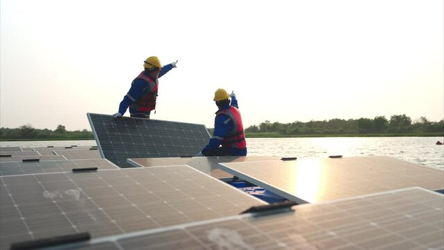 Photovoltaic engineers work on floating photovoltaics. Inspect and repair the solar panel equipment floating on the water.