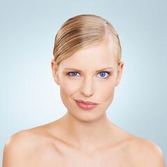 Obraz premium Portrait, beauty and funny face with natural woman in studio on blue background for wellness or cosmetics. Skincare, facial and makeup with confident young model at spa for dermatology or comedy