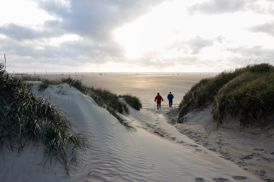 Breiter Sandstrand mit D&uuml;nen und Urlaubern auf der d&auml;nischen Nordsee Insel R&ouml;m&ouml;.
