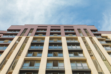 New apartment building against the sky. Facade of a residential building. Modern architecture.