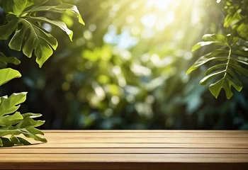 Papier Peint photo Lavable Spa Wooden table top with green leaves frame and blurred garden background with copy space. Fresh ,relaxing spa concept, displays, podium, empty  product presentation desk, visual layouts.