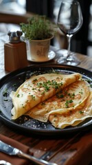 Savory Crepes Served on a Black Plate in a Cozy Bistro Setting