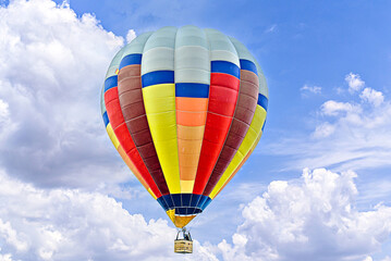 Fototapeta premium Colorful hot air balloon flying over blue sky with white clouds 