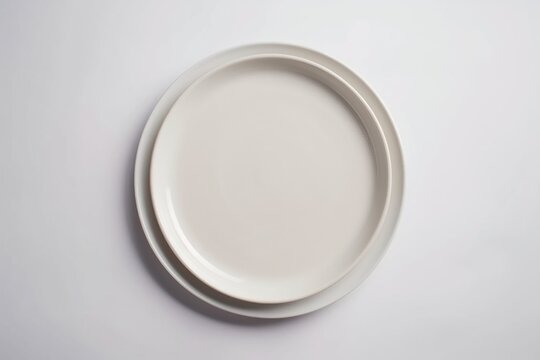 A white plate sitting on top of a table. Perfect for food and dining related designs