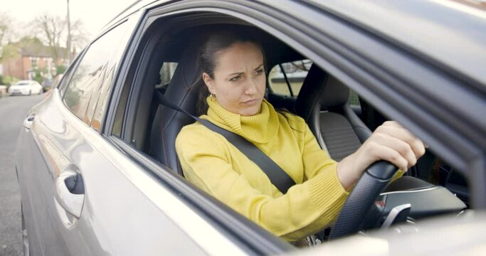 Woman driving a car and getting annoyed stuck in traffic