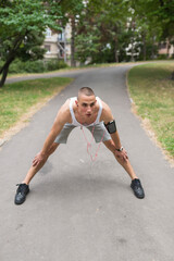 Young fitness man runner stretching legs before running