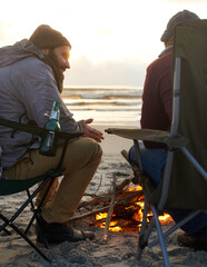 Beach, beer and fire with man friends talking on coast or shore from back for travel, holiday or...