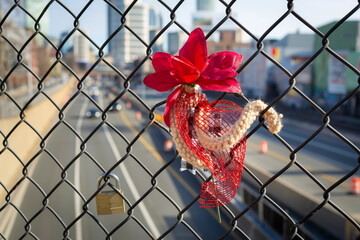 Symbolic attachments on a fence with a blurred background of an urban roadway, Boston, USA
