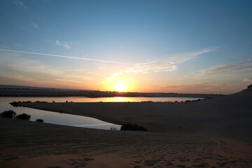 sunset scene on Magic Lake; where water comes out of deep earth & forms a lake in a heart of dessert in fayoum,  Egypt.