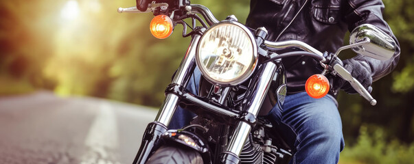 A classic motorcycle with chrome parts rides down the road. Front view. - obrazy, fototapety, plakaty