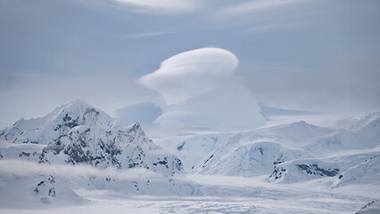 Clouds float above snow mountain ranges. Amazing Antarctic winter nature with snow capped mounts at cloudy day. Climate change and global warming concept at environment scenery of Antarctica © mozgova