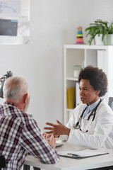 Doctor specialist consulting a patient in a doctor's office at a clinic. Female doctor is talking with a male elderly patient.