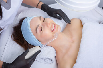 Beautiful young woman getting laser hair removal treatment at beauty salon. Beauty treatment concept.