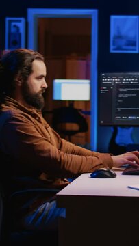 Experienced programmer writing code on computer screen while in office using java programming languages. Developer working on fixing database errors while working from home, camera B
