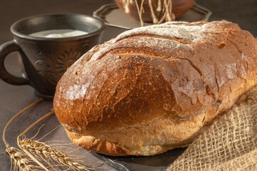 Close-up of a loaf of freshly baked homemade bread on the table. Whole-grain white bread. Healthy food, bread on sourdough. Close-up