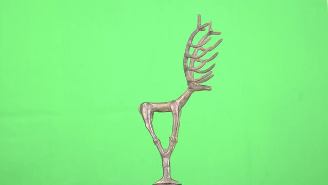 4K video of an anatolian deer statue made from bronze shot on a rotating platform in front of a green screen