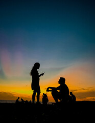 silhouette of a couple with their puppy