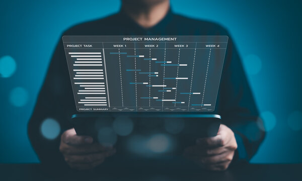 Efficient Project Management. Engineer or site manager utilizes computer tablet for construction planning with Gantt charts. Track engineering progress, update tasks, and generate reports seamles