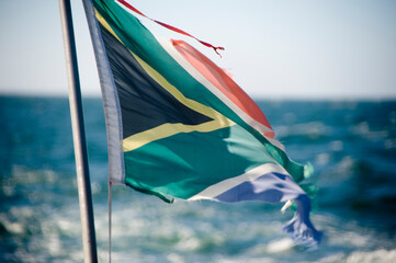South African Flag with the sea behind