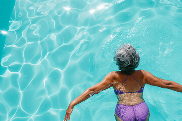 Senior afro american woman swimming in the pool.