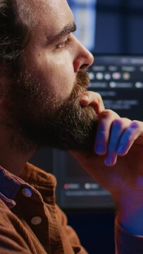 Software engineer puzzled in front of computer screen while writing complex code. Admin feeling confused while trying to fix database errors while working from home, camera B close up