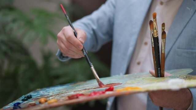 Painter mixes pigments on slab closeup
