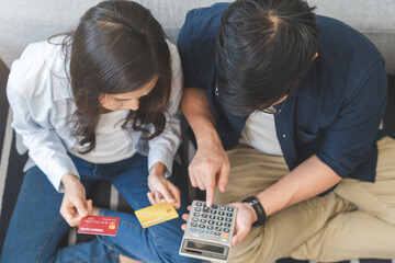 Stressed financial owe asian young couple love sitting stressed and confused hand calculate expense from credit card, invoice no money to pay, mortgage or loan. Debt, bankrupt or bankruptcy people.