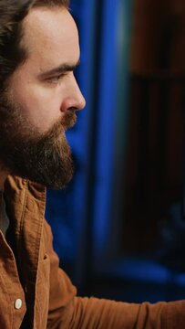 Focused programmer drinking coffee in apartment while solving database errors on computer. Remotely working IT admin concentrated on finalizing coding project in home office, camera A
