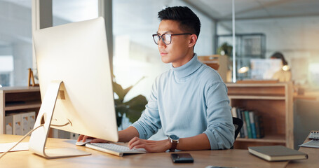 Asian man at computer, glasses and ideas, thinking and reading email, web review or article at...