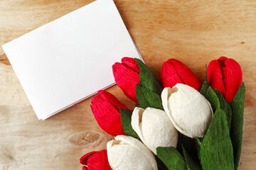 Naklejka na ściany i meble Bouquet of red and white craft paper tulips and white mockup blak on wooden background. Mother's Day or Women's Day greeting card