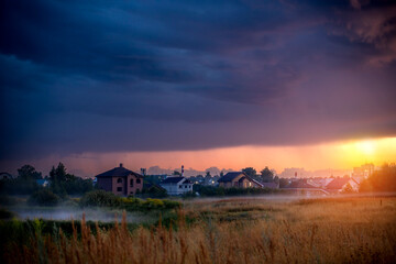 Obraz premium Stormy sky with dramatic clouds from an approaching thunderstorm at sunset. Stormy sky over the village.