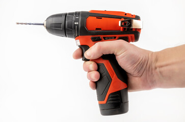 A cordless drill in the hand of a master. The concept of furniture production and repair.