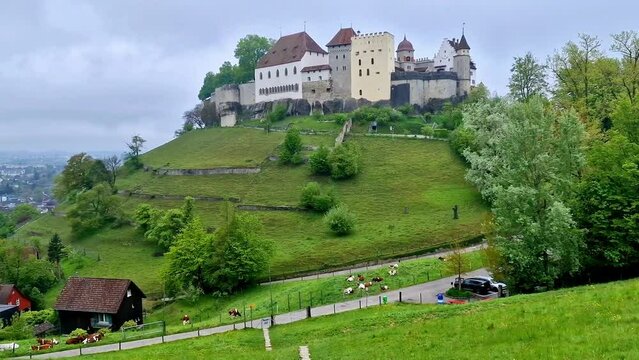 Great medieval historic castles of Switzerland - Lenzburg in the Canton of Aargau, view with grazing cows over pastures. 4k hd video