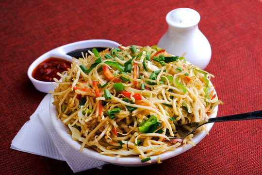 Schezwan Noodles or vegetable Hakka Noodles, or chow mein is a popular Indo-Chinese recipes, served in a bowl, Stir-fried noodles.