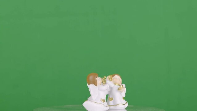 4K video of a small angel statues shot on a rotating platform in front of a green screen