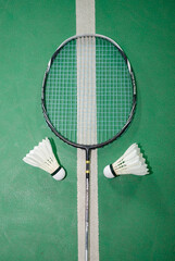 Badminton rackets and white cream badminton shuttlecocks after playing or after games on green...